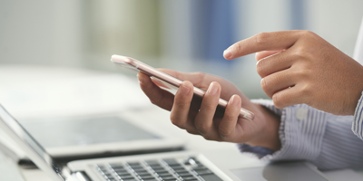 Person at a computer using calculator on their phone